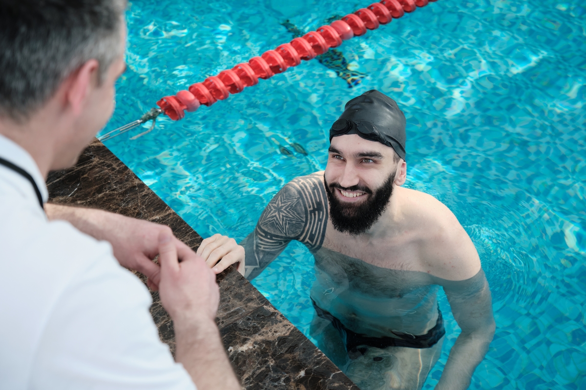 smiling-swimmer-listening-to-coach-2025-03-16-11-01-53-utc